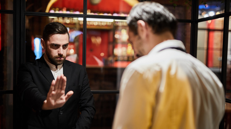 person being stopped before entering restaurant