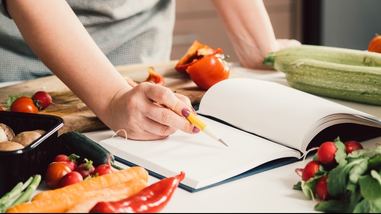 hand writing in book in kitchen