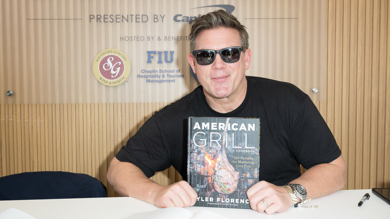 Tyler Florence holds up a copy of his cookbook "American Grill"