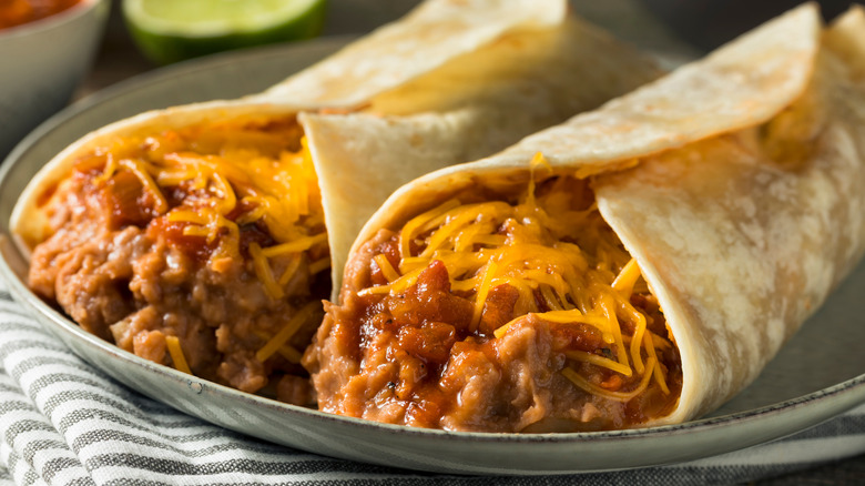 Cheesy burritos on plate