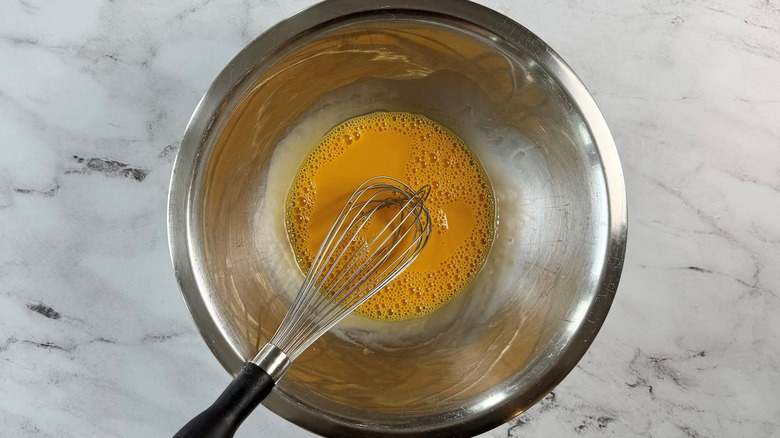 Egg yolk mixture with whisk in bowl