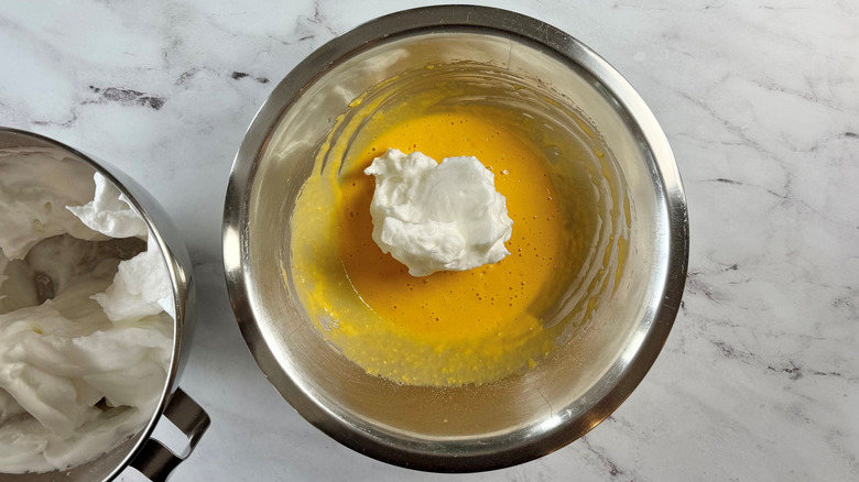 Egg yolk mixture with stiff egg whites on top in bowl