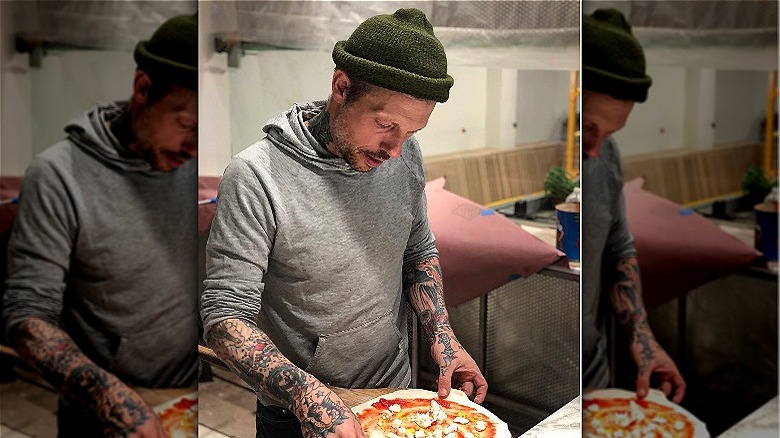 Person in kitchen making pizza