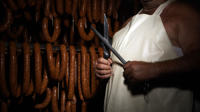 butcher with knife and sausages