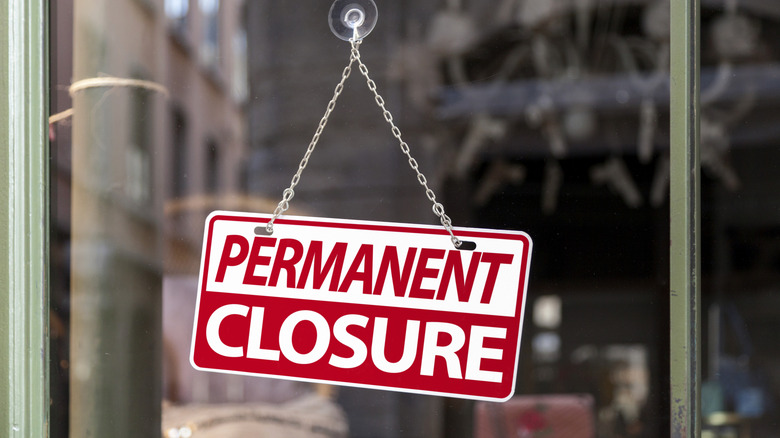 Permanent closure sign hanging on glass door
