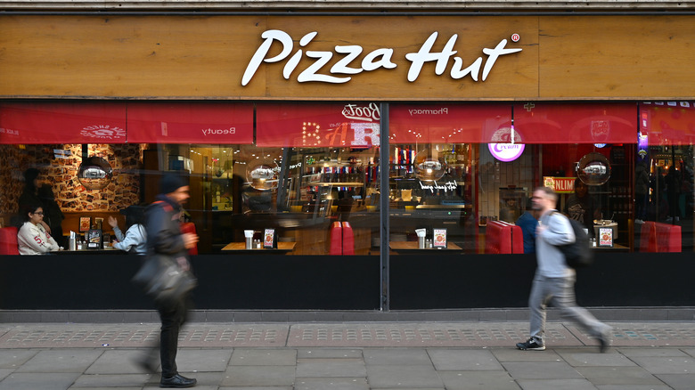 People walking in front of Pizza Hut