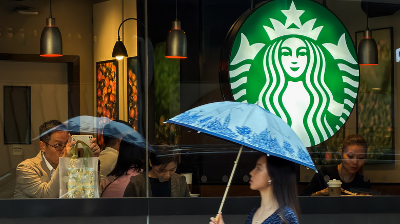 Woman with umbrella in front of Starbucks