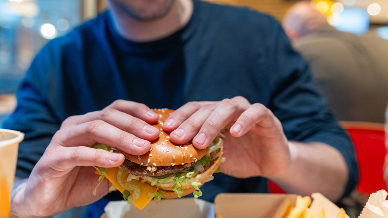 Four people looking up at the menu inside a fast food restaurant