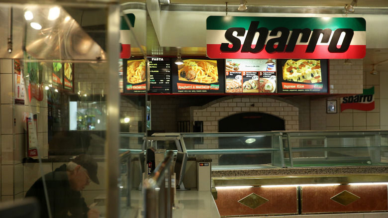 A male customer sitting at a table inside a Sbarro