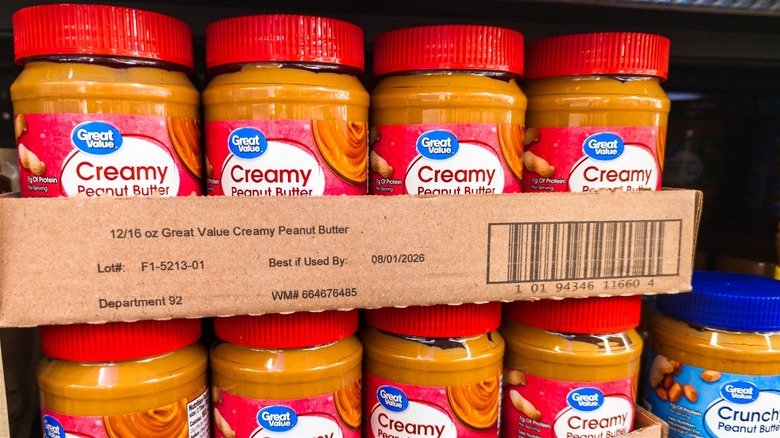 Jars of Great Value peanut butter on display at a grocery store.