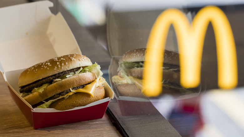 A Big Mac hamburger next to the McDonald's logo