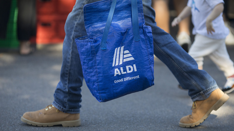 man holding Aldi shopping bag
