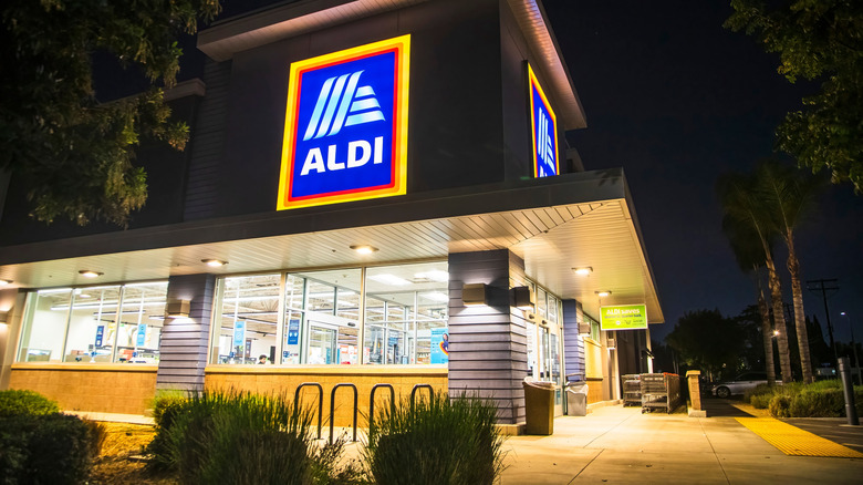 Outside of an Aldi grocery store illuminated at night.