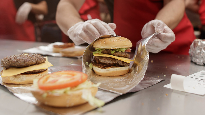 Five Guys employee wrapping double cheeseburger in foil.
