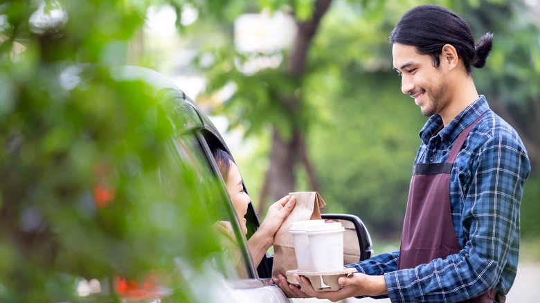 employee serving customer at drive-thru