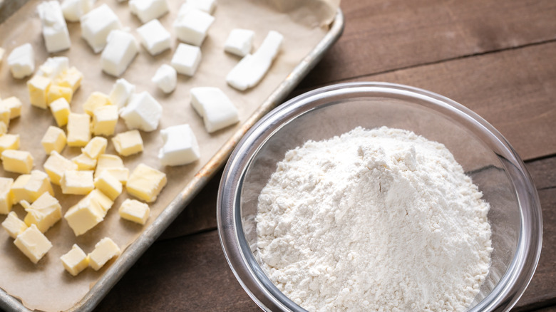 Bowl of flour next to a sheet pan 