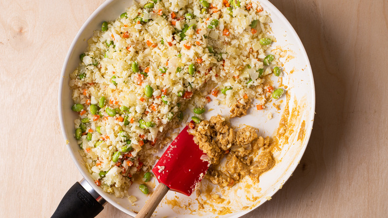 Cauliflower fried rice with scrambled egg in a skillet.