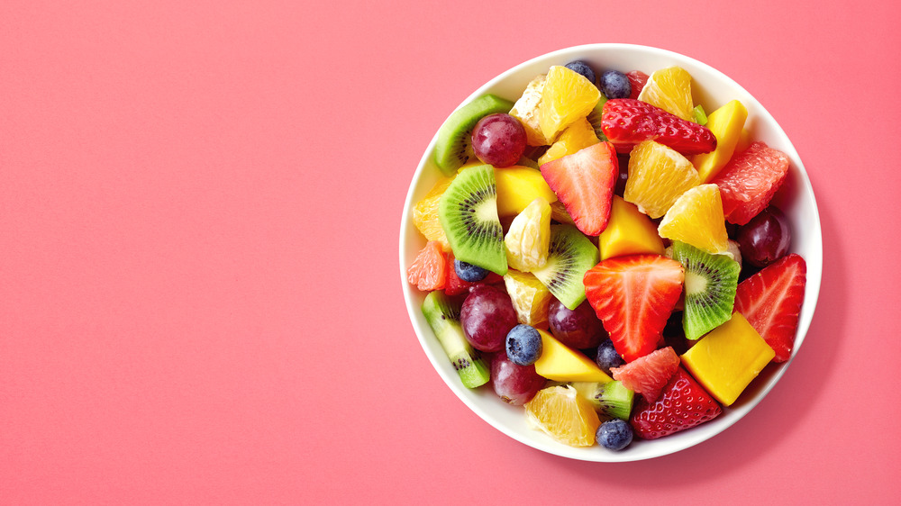 bowl of fruit with berries, kiwi, oranges and grapes