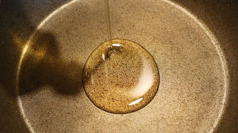 Pouring corn oil into pan