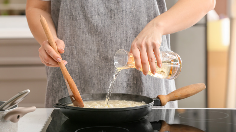 Liquid being added to a pan of risotto