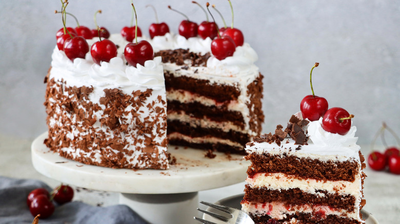 Black Forest cake on stand with one slice taken out