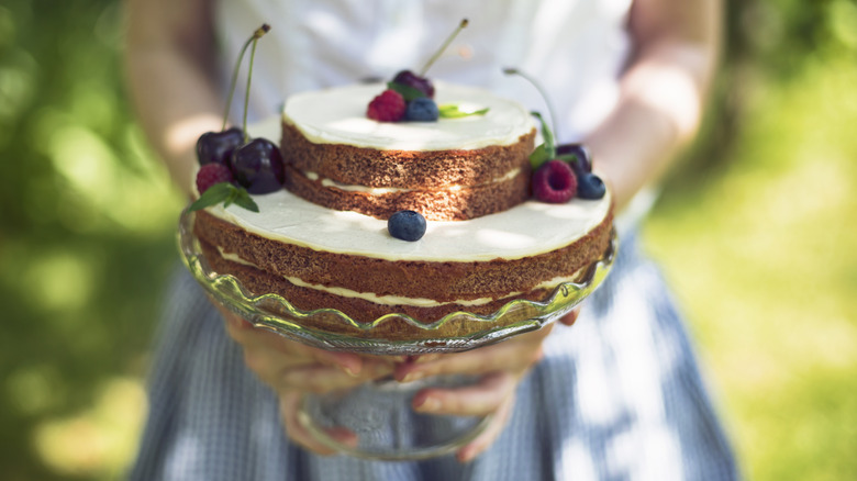 person holding cake with berries