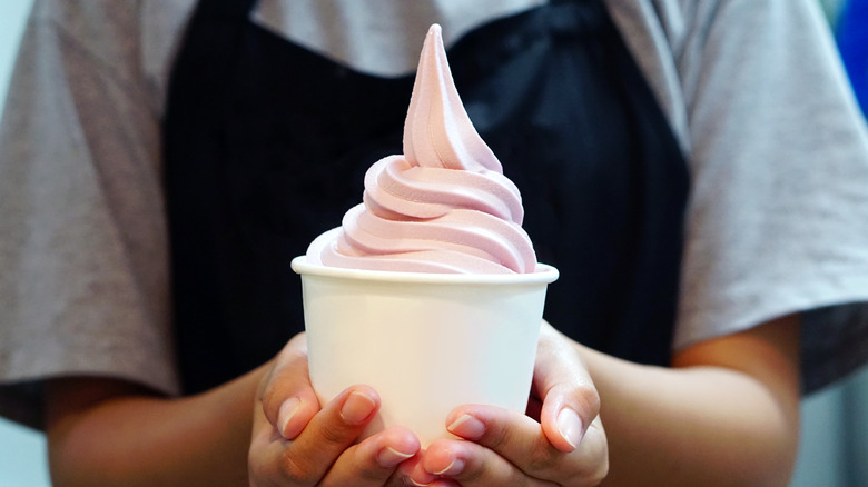 server holding cup of frozen yogurt