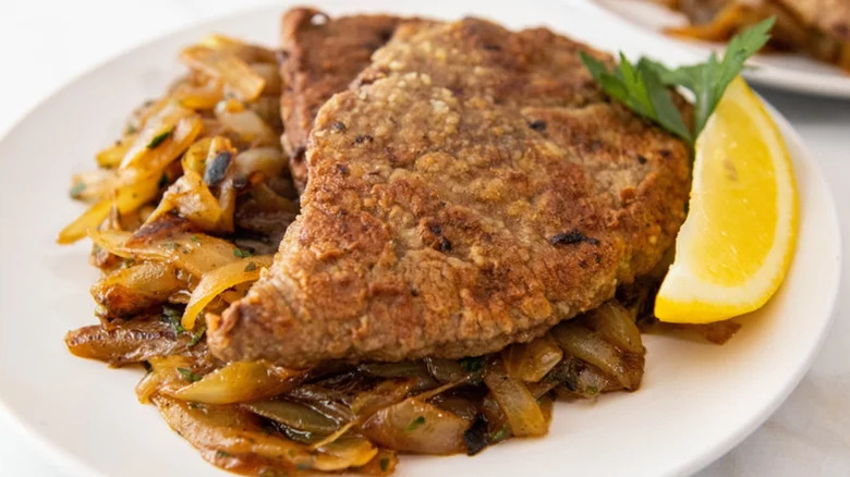 liver and onions served with a lemon on side