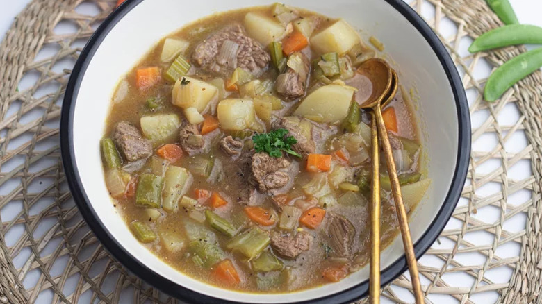 vegetable beef soup with spoons in bowl