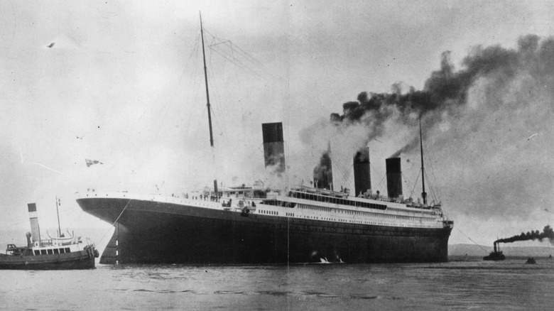 Black and white photo of Titanic with a tugboat nearby