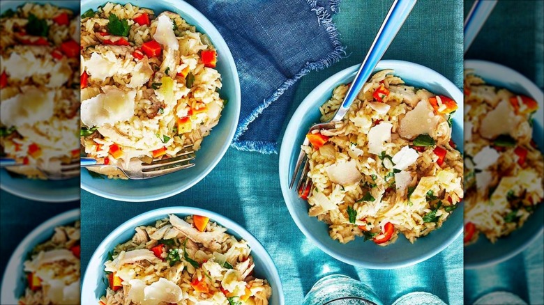 Three bowls of bog chicken with forks on a blue tablecloth