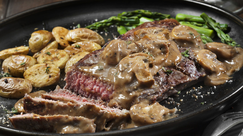 Steak Diane with potato and asparagus side dishes