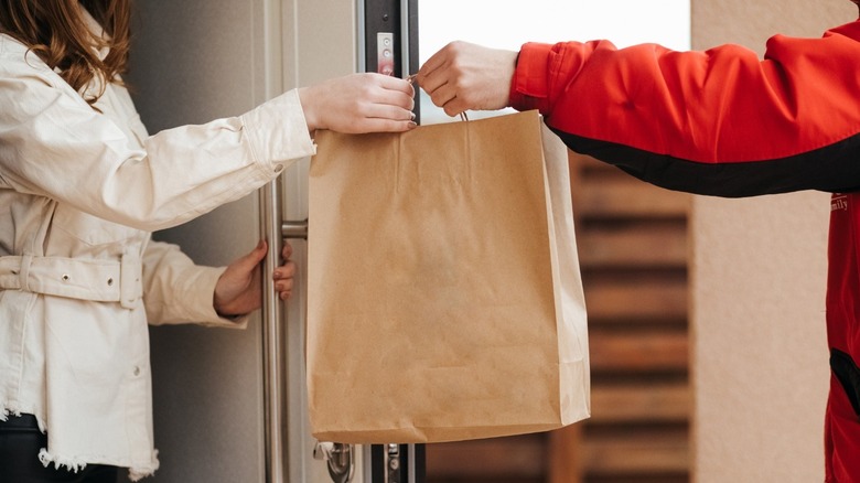 Woman receiving food delivery order from driver
