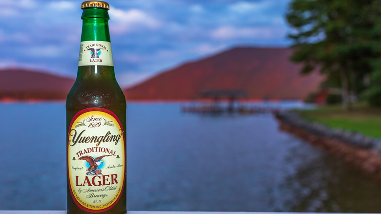 Yuengling bottle with lake and mountains in background