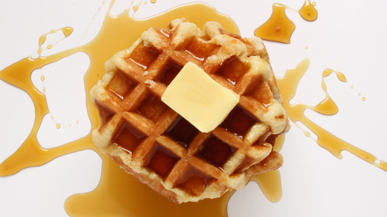 A waffle with butter and syrup