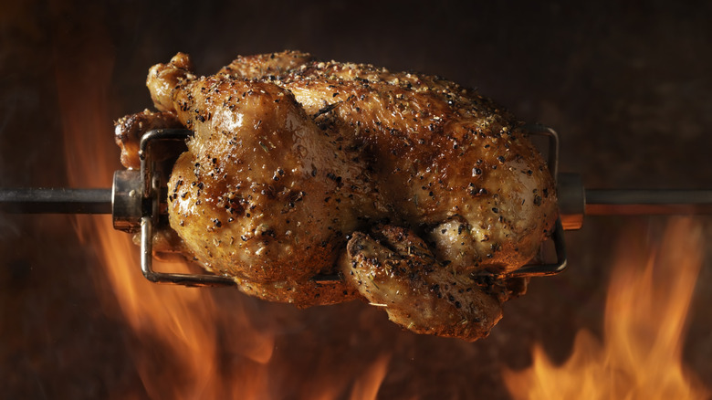 rotisserie chicken with flames in background