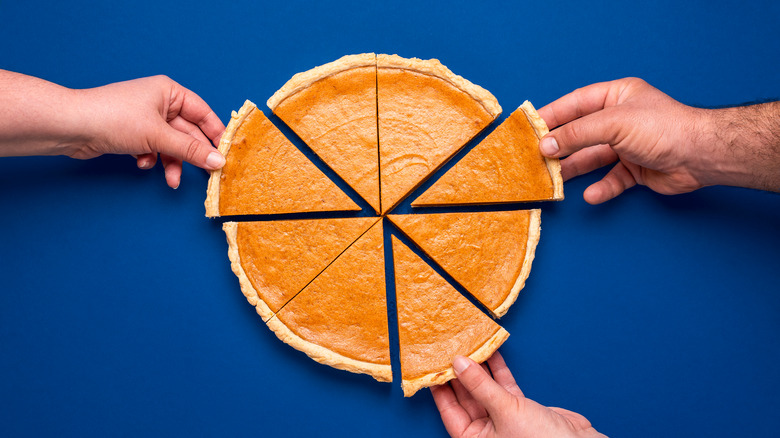 Sliced pumpkin pie on a blue background