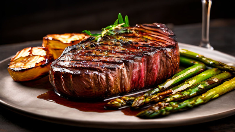 Crispy seared steak on plate with asparagus