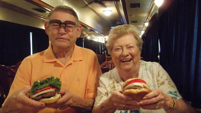 customers holding burgers at Bob's Train