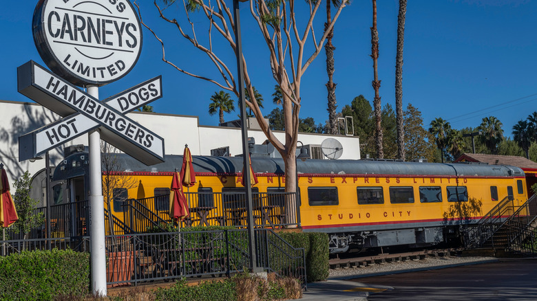Carneys sign with yellow rail car in background