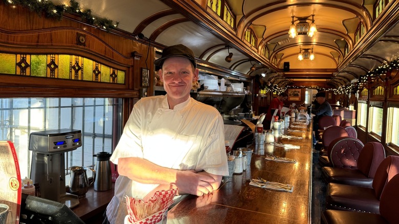 man in chef whites leaning against counter in Frank's Diner