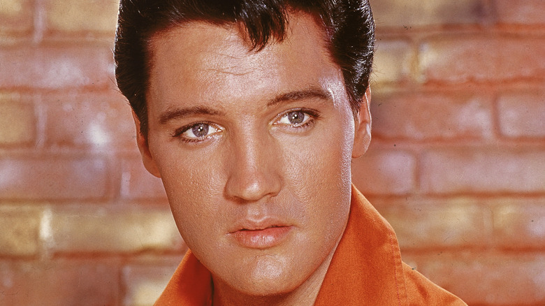 Elvis Presley in front of a brick wall