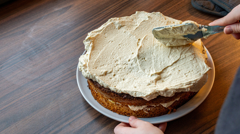 A person frosting a cake