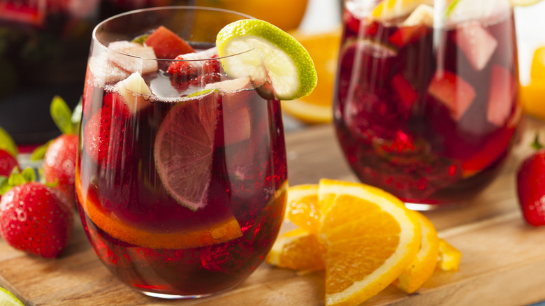 Cocktails with fruit chunks inside and fruit spread on the table.
