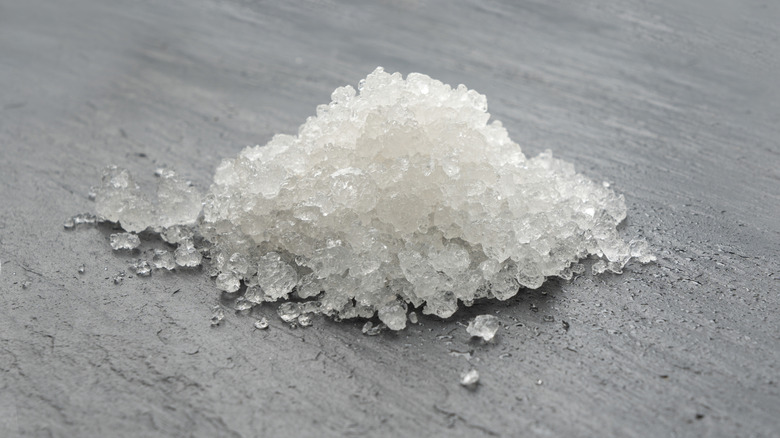 Pile of iodized rock salt on a countertop.
