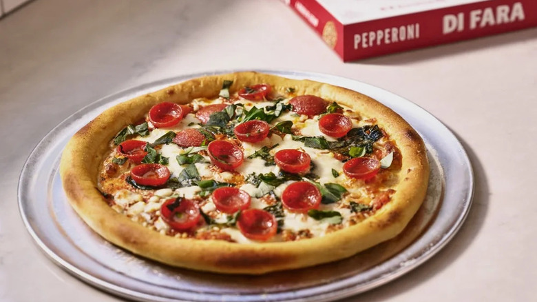 A cooked pepperoni pizza with a Di Fara box in the background