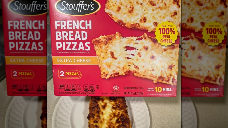 Stouffer's French bread pizza box next to the prepared pizza on a white plate