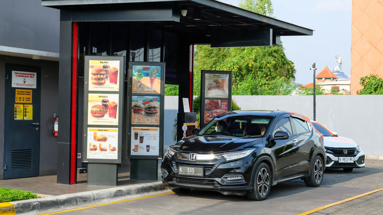 A black SUV going through the McDonald's drive through
