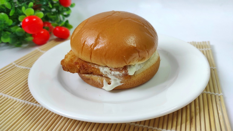 Filet-O-Fish sandwich on a white plate atop a bamboo placemat