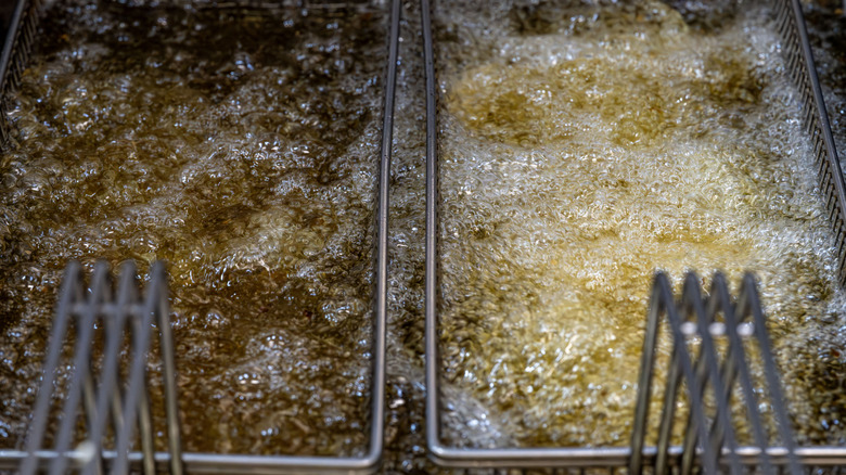 Two deep friers side-by-side filled with bubbling oil